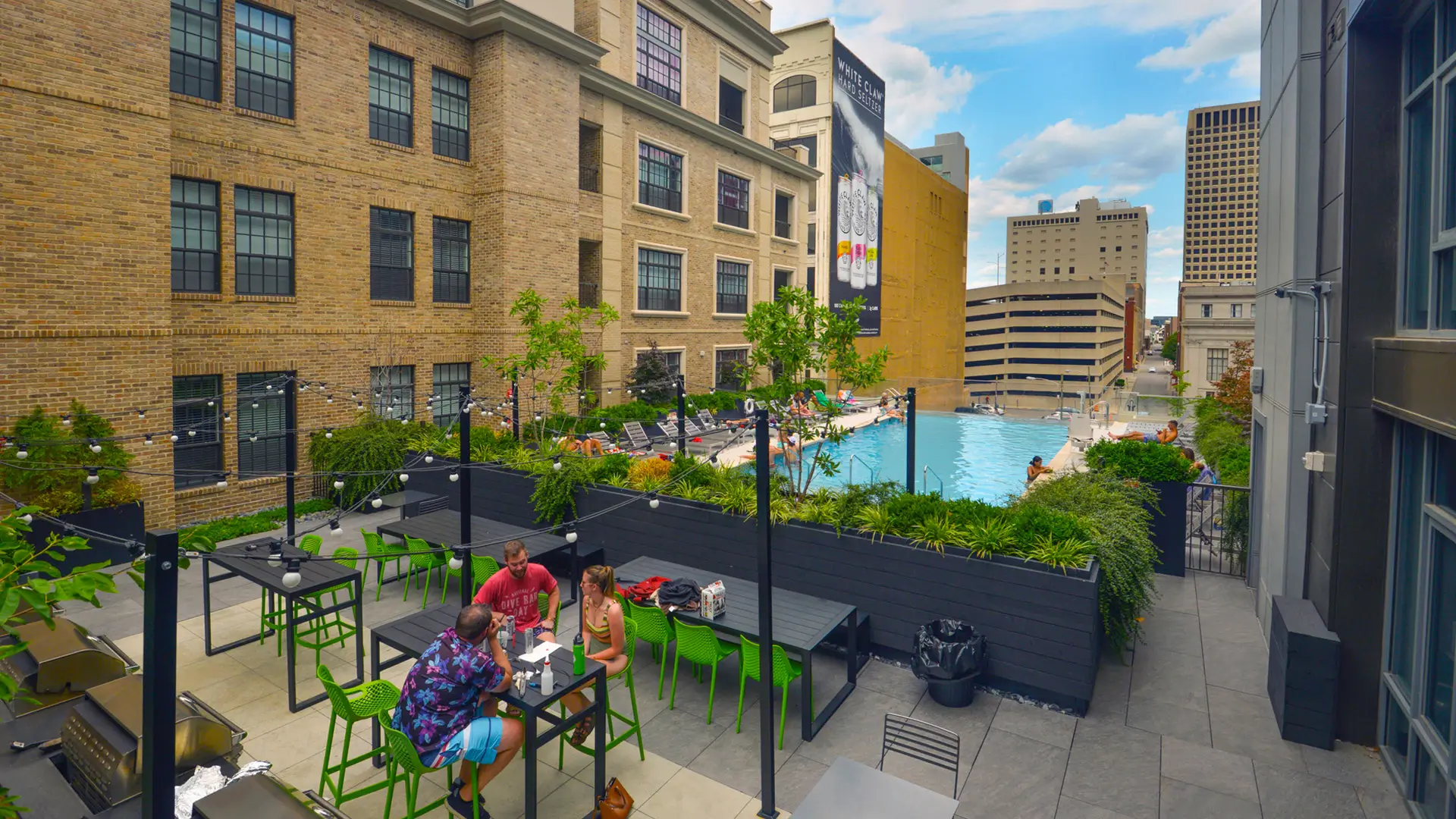 Rooftop patio with three people and pool