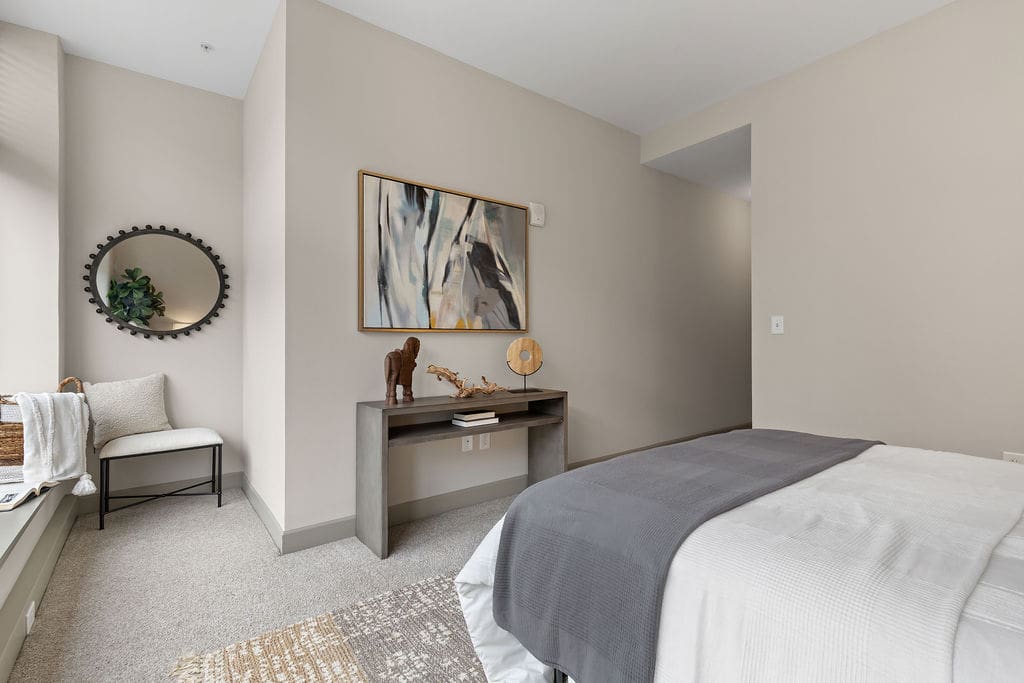 Neutral bedroom with bed, console table, mirror