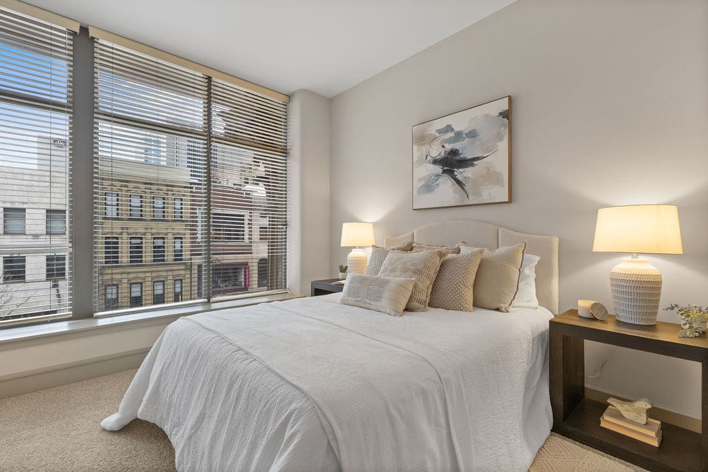Bright neutral bedroom with large city-view window