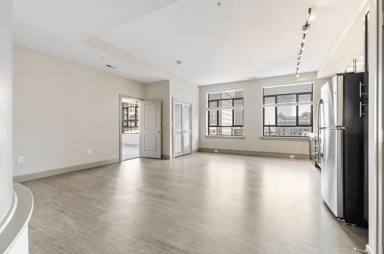 Spacious empty apartment living area with kitchen
