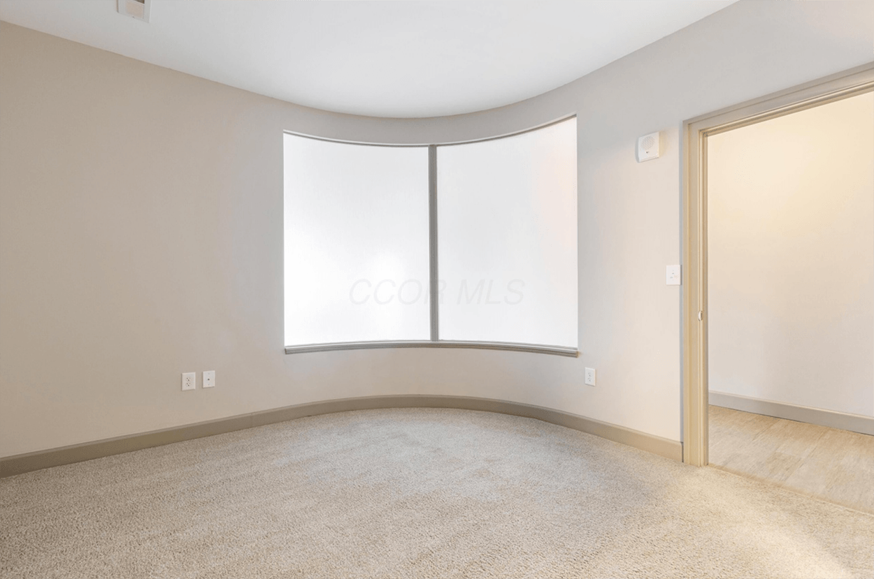 Empty beige room with curved frosted window