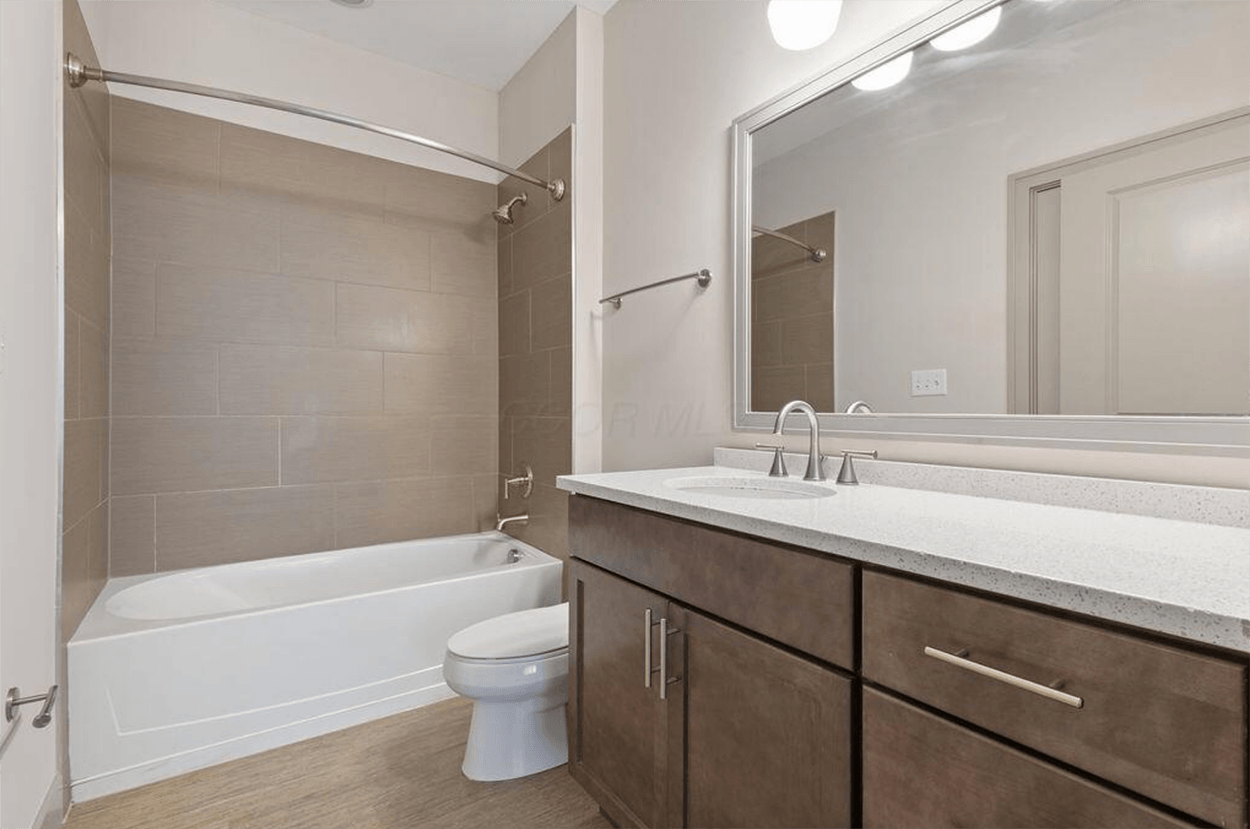 Modern bathroom with tub, vanity, and toilet