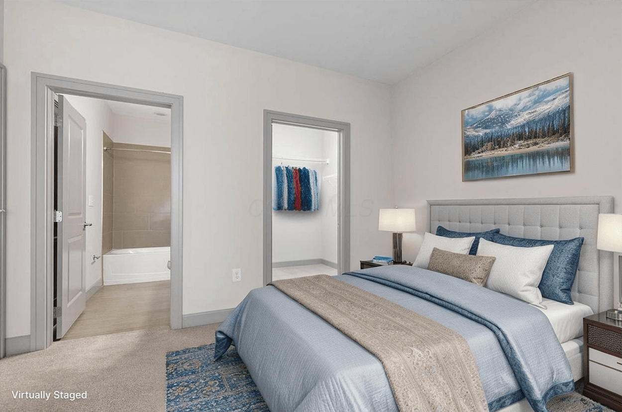 Staged bedroom with blue bedding and bathroom