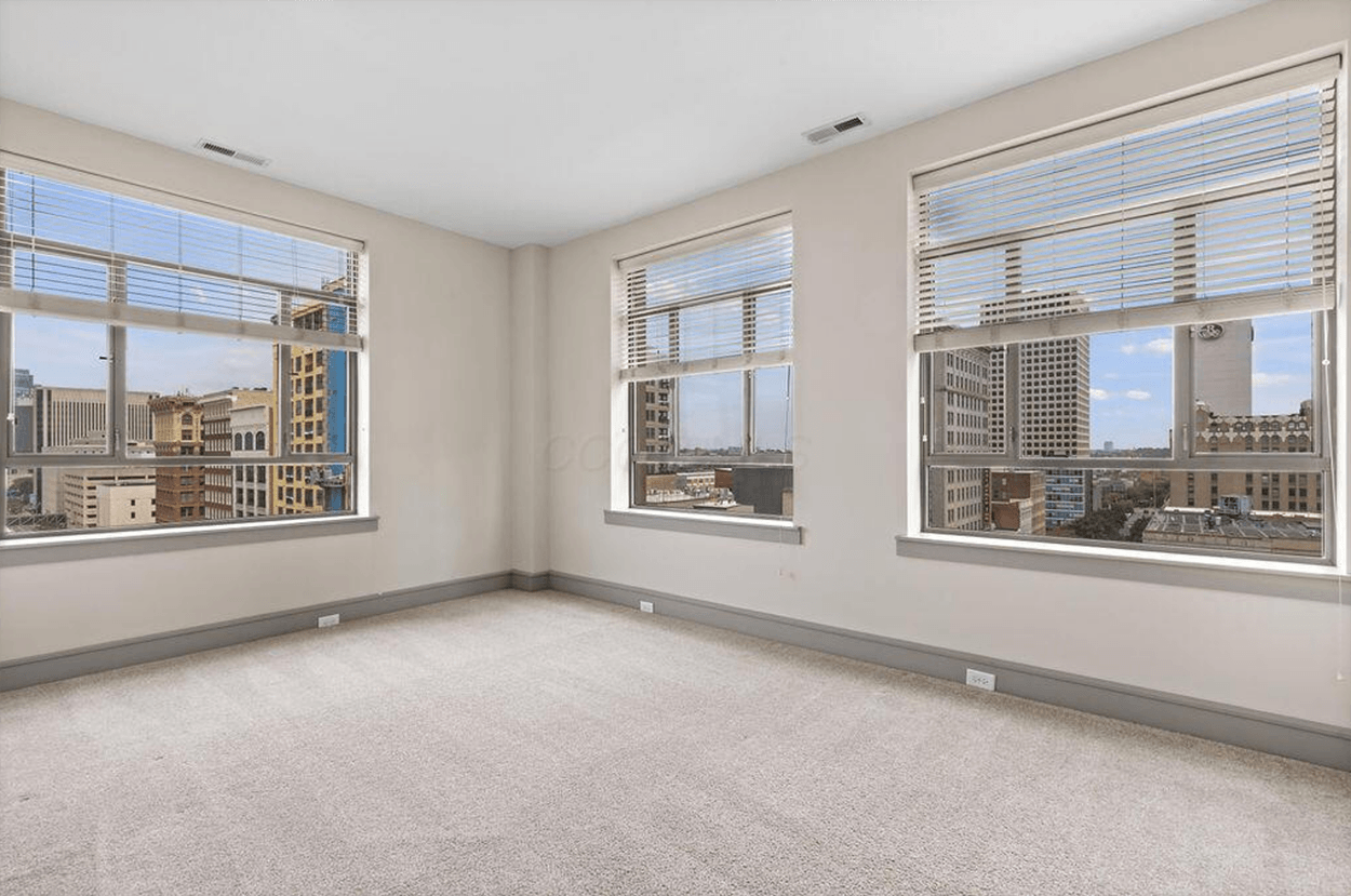 Empty room with three city-view windows